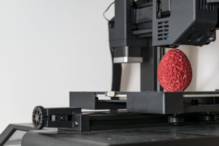 98105490 close up of a 3d printer printing a red polygonal egg La evolución histórica de las impresoras hasta la actualidad